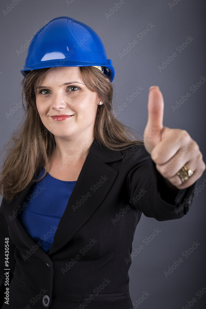 Happy young woman with hardhat showing ok sign Happy young woman with hardhat showing ok sign