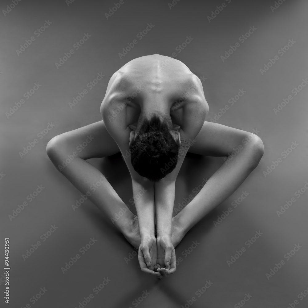 Naklejka premium Nude yoga. Beautiful sexy body of young woman on black background