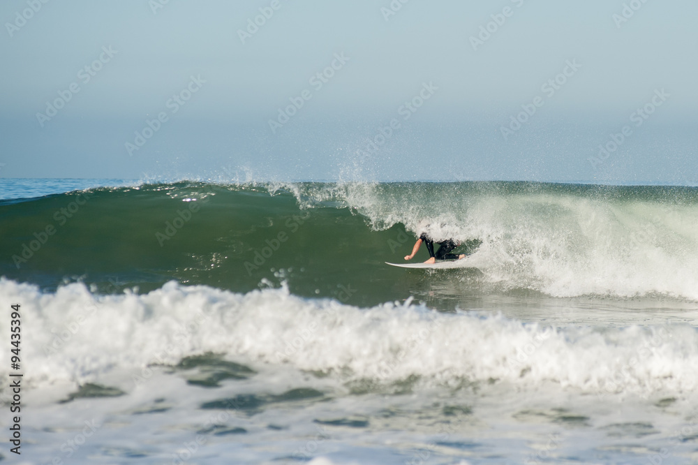 Surfer tucked in the tube of a wave going right. Surfer tucked in the tube of a wave going right.