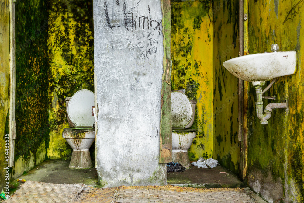 A grungy, messy public restroom with a dirty sink and toilet, perfect ...