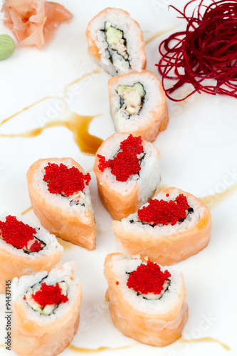 Sake kani sushi rolls elegantly presented on a pristine white plate in a studio setting showcasing the exquisite craftsmanship of Japanese culinary artistry