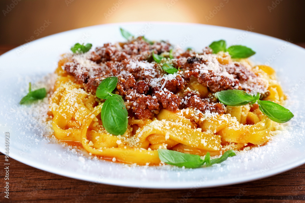 Pasta Bolognese with parmesan and basil on dark background