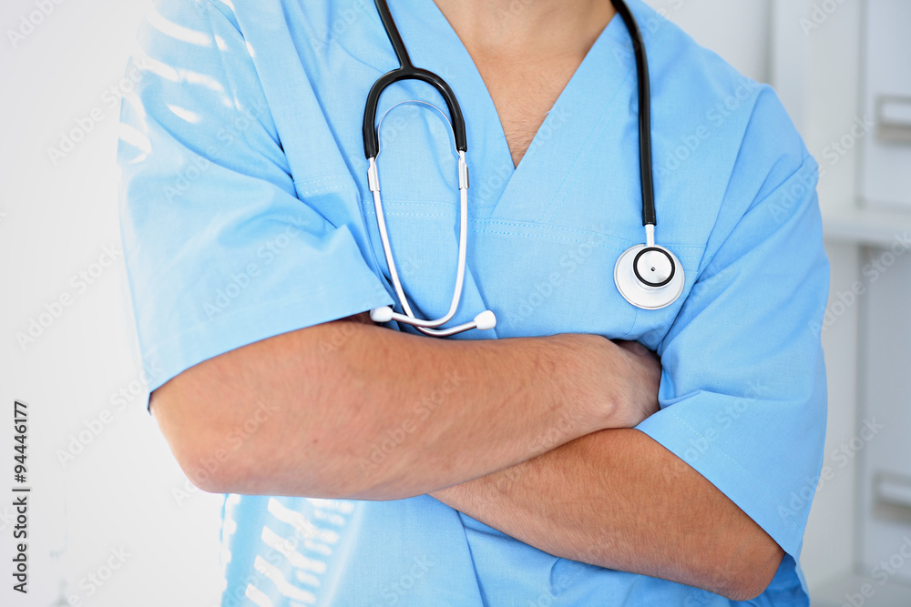 Portrait of unknown male surgeon doctor holding his stethoscope, crossed arms Portrait of unknown male surgeon doctor holding his stethoscope, crossed arms