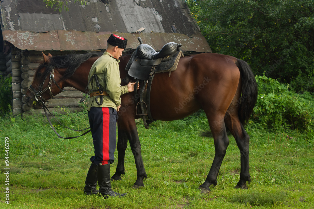 Russian Cossack with a horse resting in the summer field