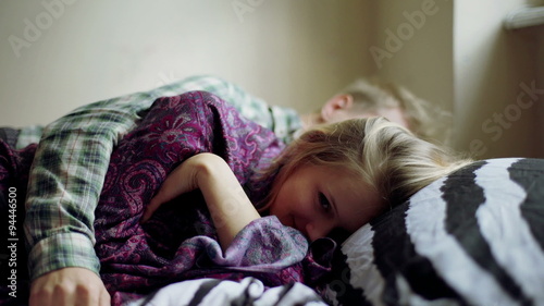 Couple lying together on the bed and girl looking tired

