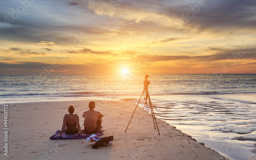 Couple sitting on the sunset beach, in Phuket