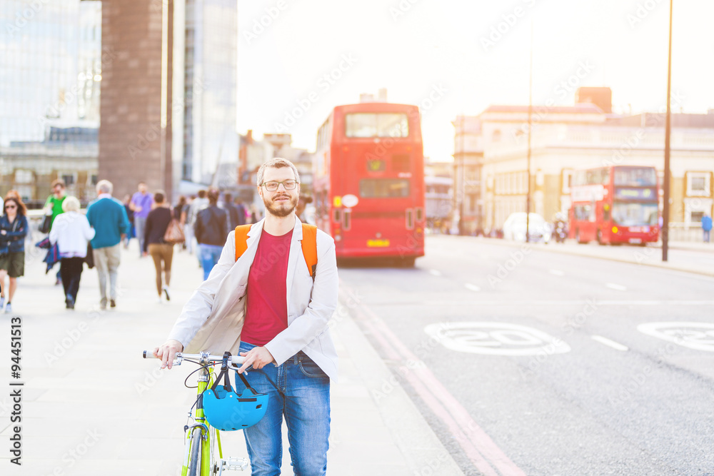 Hipster man walking on London bridge and holding his fixed gear - obrazy, fototapety, plakaty 