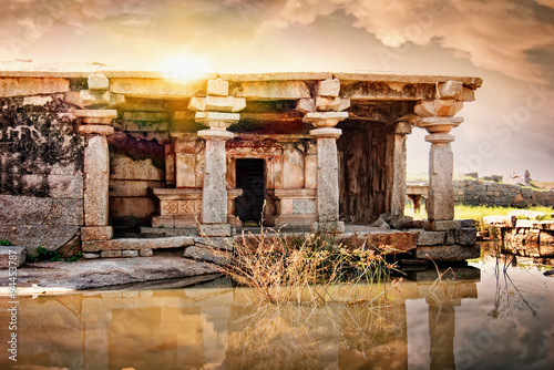 Ancient ruins of Vijayanagara Empire in Hampi at sunset sky, Karnataka, India.
