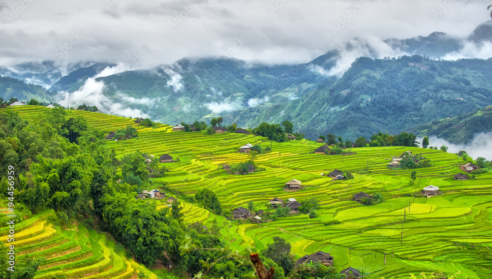 A corner of the hill villages of Ha Giang with clouds covering the mountain permissive and small houses on the terraces in the afternoon sun picture letter most beautiful country I've ever seen