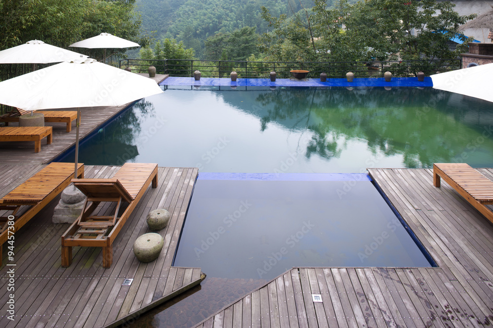 Umbrella chair in hotel pool resort with sunset Umbrella chair in hotel pool resort with sunset