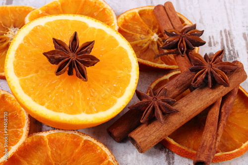 Dried and fresh orange with spices on old wooden background