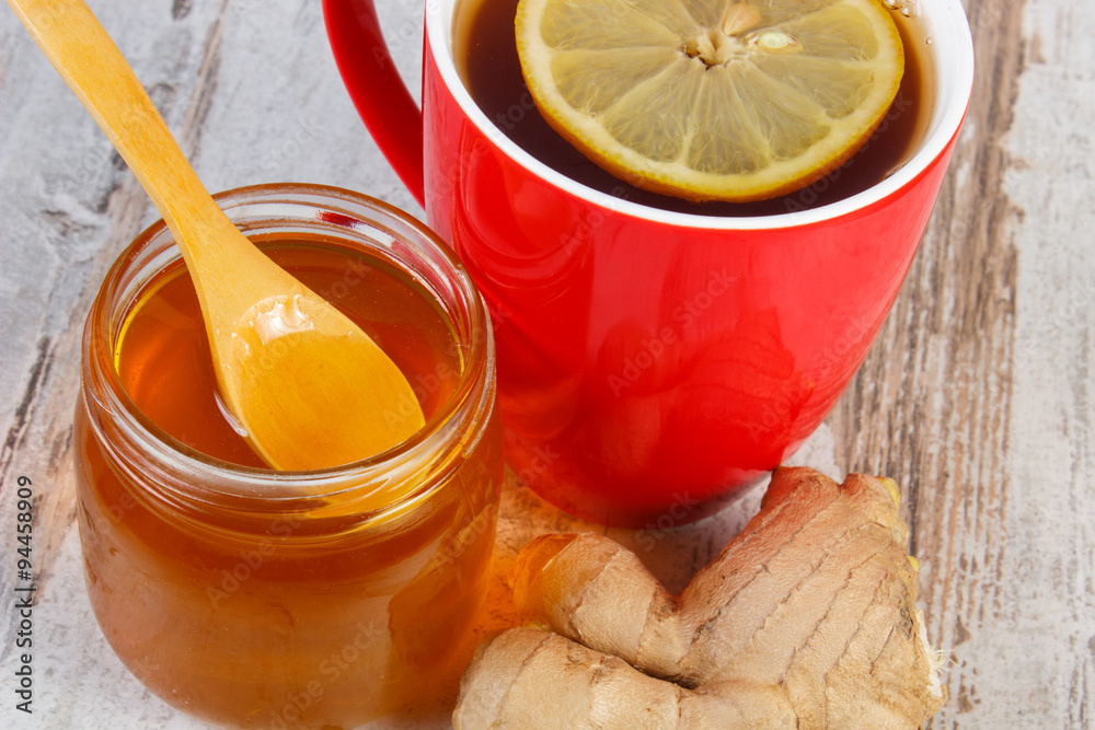 Honey, ginger and cup of tea with lemon on wooden table, healthy nutrition Honey, ginger and cup of tea with lemon on wooden table, healthy nutrition