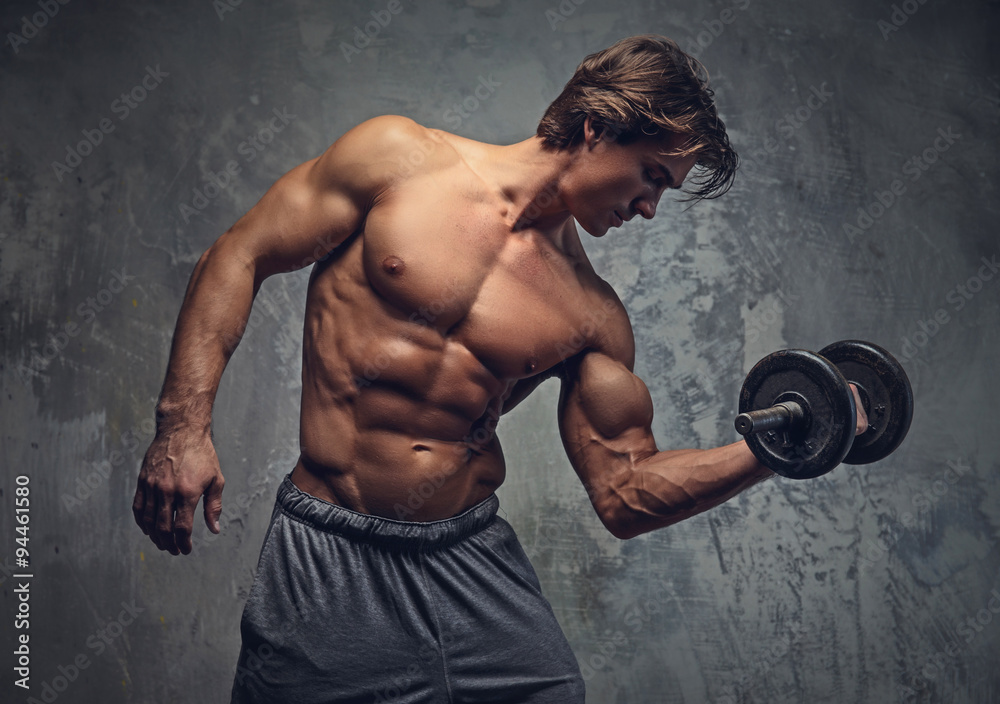Shirtless bodybuilder doing exercises. Stock Photo Adobe Stock