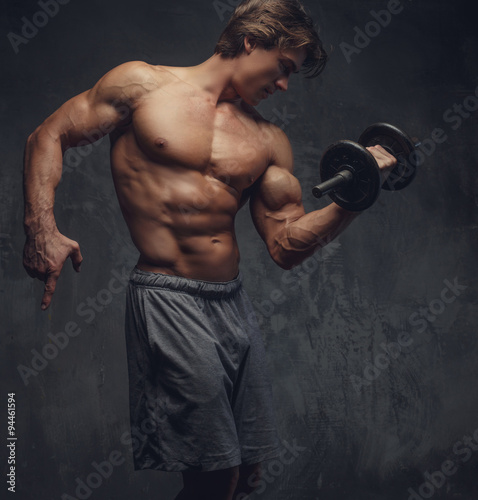 Shirtless bodybuilder doing exercises. © Fxquadro