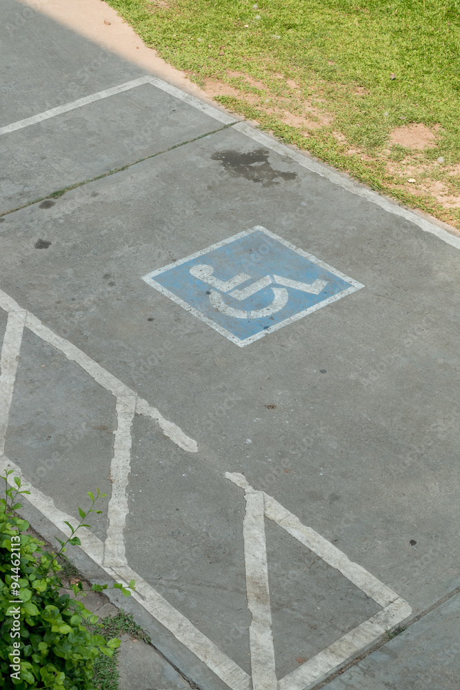 Obraz premium parking space reserved handicapped on road with disabled sign