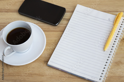 Smartphone, pen and cup of coffee on wood table - Work office supplies 