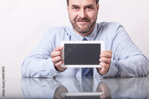 Business man on office desk, showing tablet computer with empty