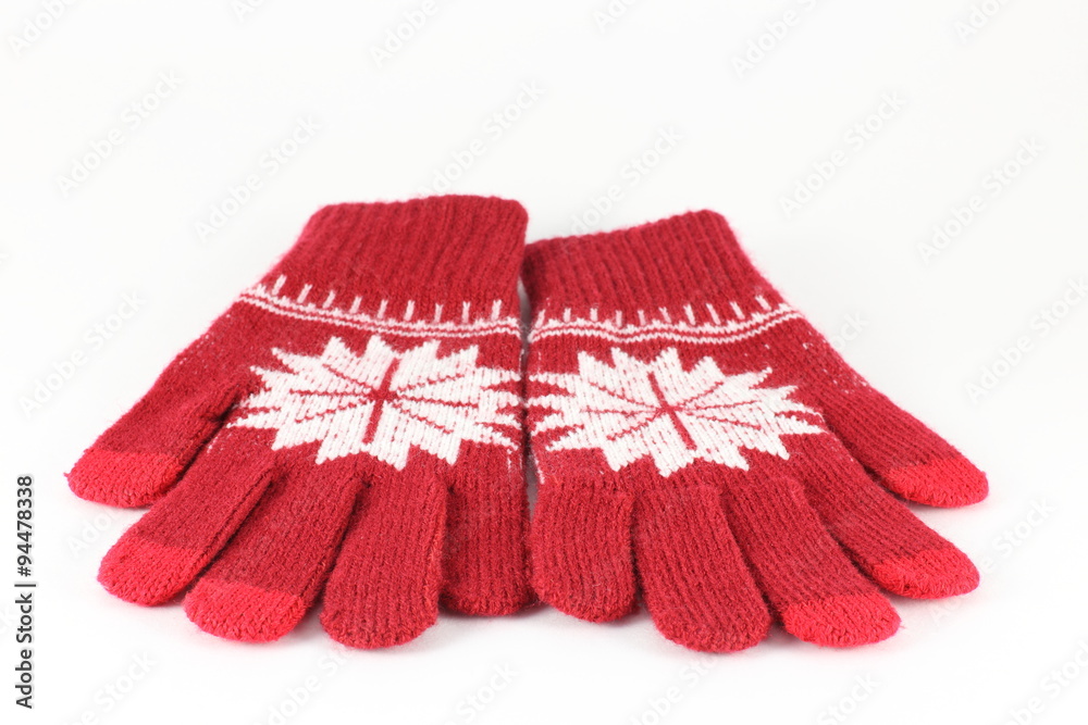 Pair of red knitted gloves with pattern snowflake, isolate on white Pair of red knitted gloves with pattern snowflake, isolate on white