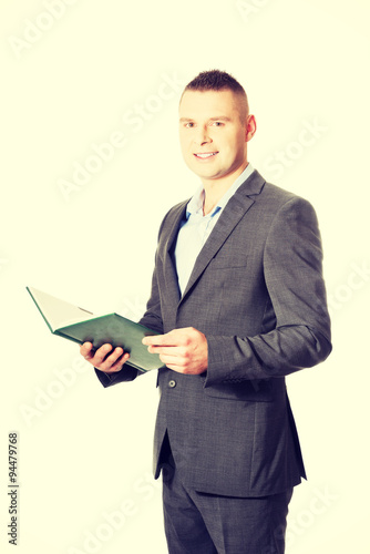Young businessman reading his note book