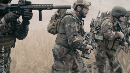 Slow motion of armed soldiers running forward to attack 