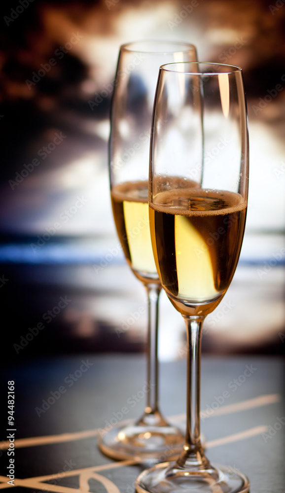 Champagne glasses on tropical beach at sunset - exotic New Year