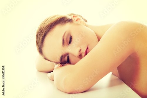 Beautiful spa woman resting her head on desk.