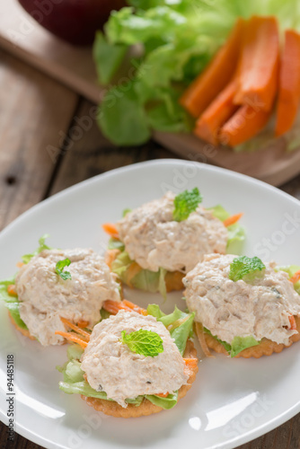 Crackers with tuna salad on white palte.