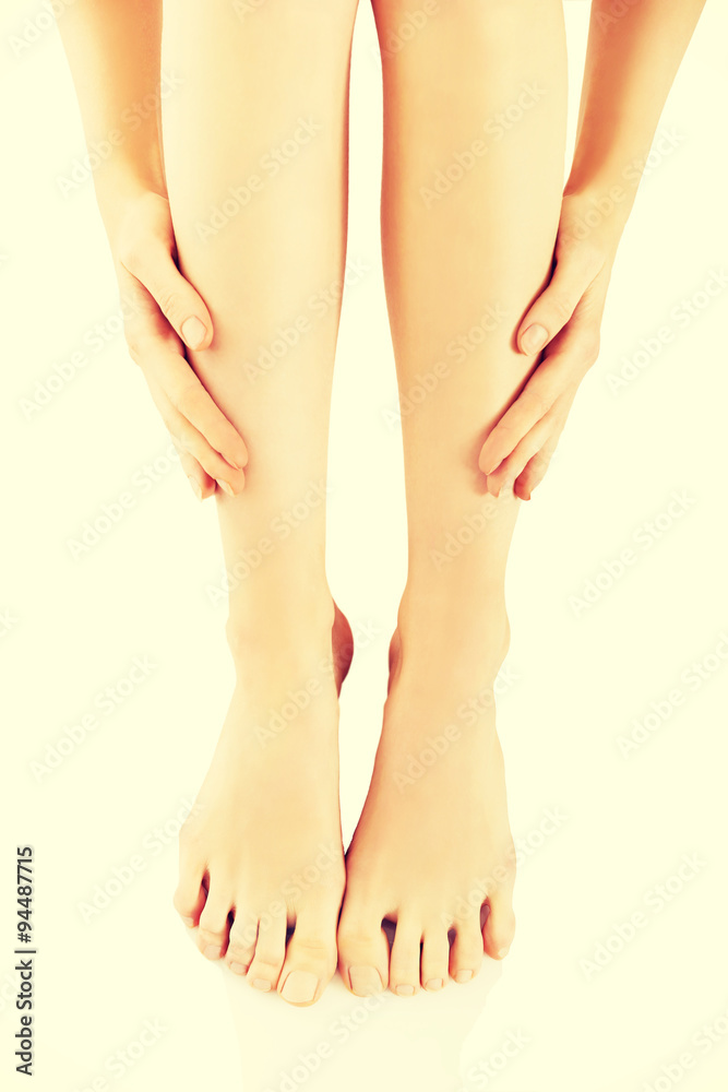 Woman massaging her legs after depilation Woman massaging her legs after depilation