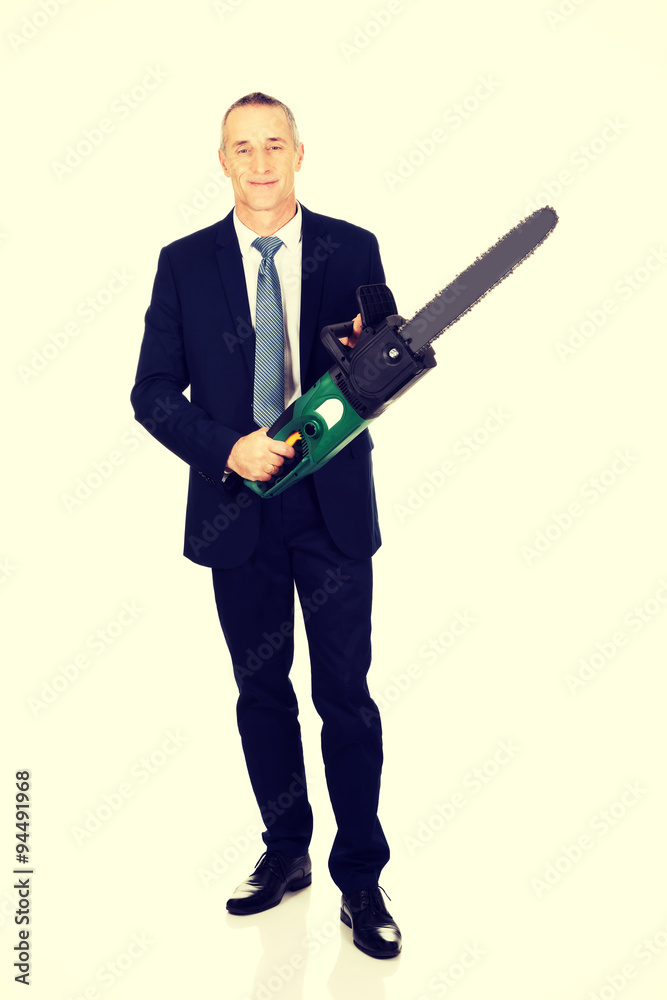 Smiling businessman with chainsaw Smiling businessman with chainsaw