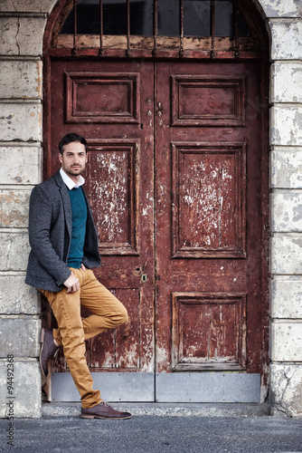 Fashionable man standing in a vintage city doorway