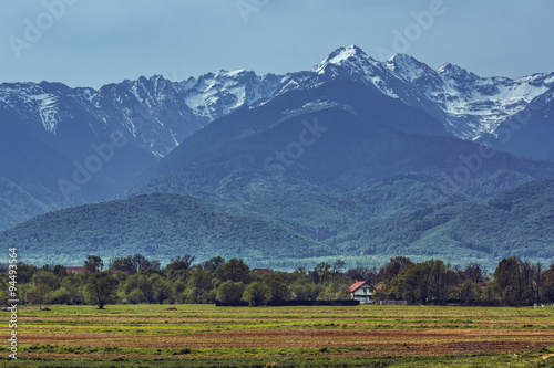 Peaceful alpine landscape with snowy Fagaras mountain range during spring season.