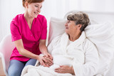 Happy carer assisting senior woman