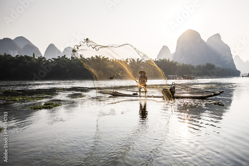 cormorant fisherman throwing a net