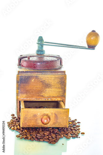 Old coffee grinder with beans on white background