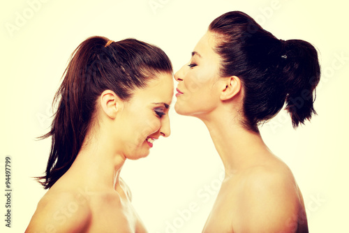 Woman kissing friend in forehead.