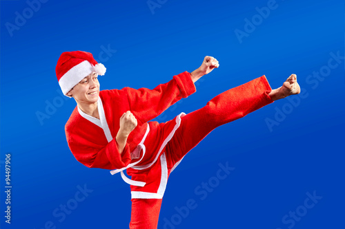 Girl in Santa Claus clothes doing karate techniques