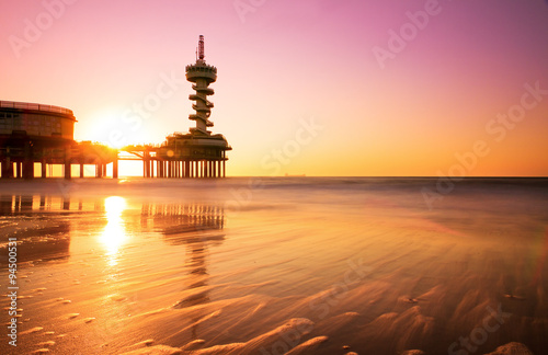 Pink sunset reflected in the water of Scheveningen, the Netherlands photo