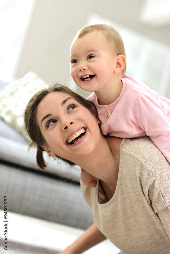 Baby girl laughing on her mom's back Baby girl laughing on her mom's back