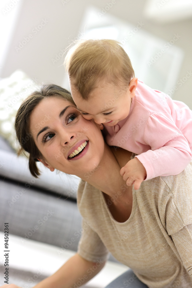 Fototapeta premium Baby girl laughing on her mom's back