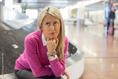 Frustrated woman lost her luggage in airport photo