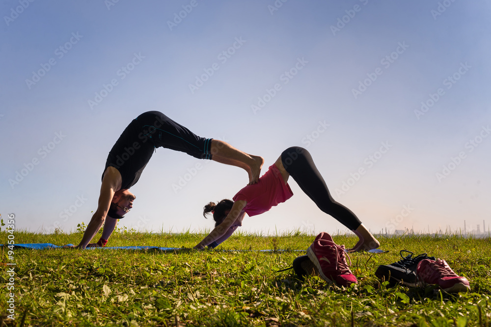 Fototapeta premium beautiful couple doing acro yoga on the beach