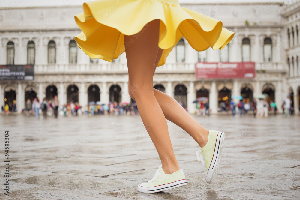 Cheerful young woman wearing sneakers and yellow skirt - obrazy, fototapety, plakaty 