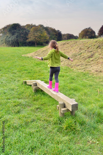 enfant jouant sur une poutre