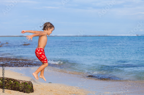  Portrait of little boy standing on the beach at the day time