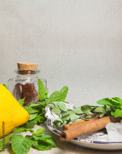 herbs for tea and a lemon on a linen background