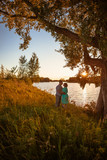 Romantic couple standing and kissing on background summer lake  sunset