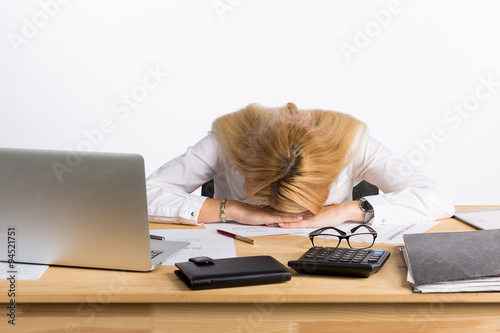 Tired businesswoman sleeping on the desk