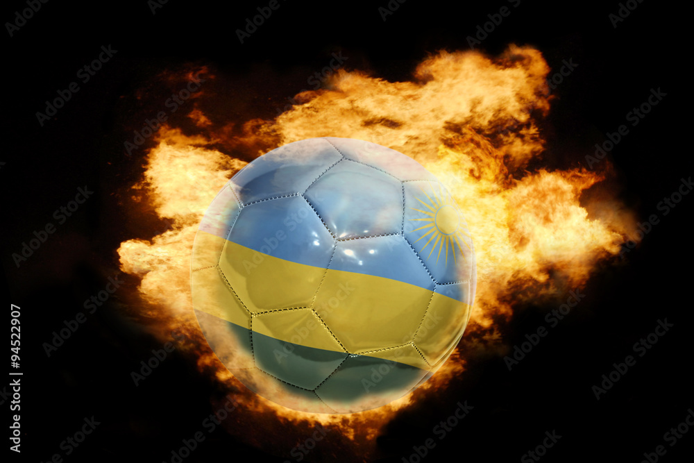 Fototapeta premium football ball with the flag of rwanda on fire