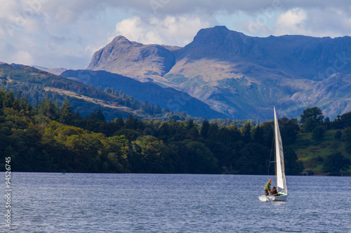 Fototapeta Naklejka Na Ścianę i Meble -  Sailboat in Lake Windermere,  Cumbria, UK, with the forest and mountains in the background