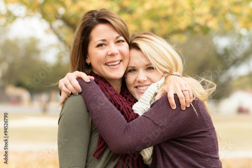 Mother and teenage daughter hugging.